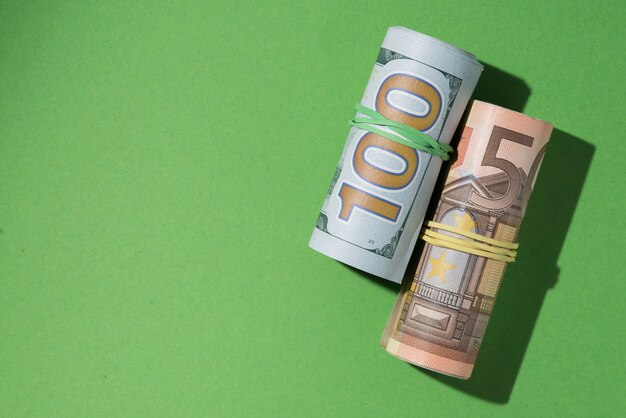 Vue élevée des billets roulés sur fond vert Photo gratuit