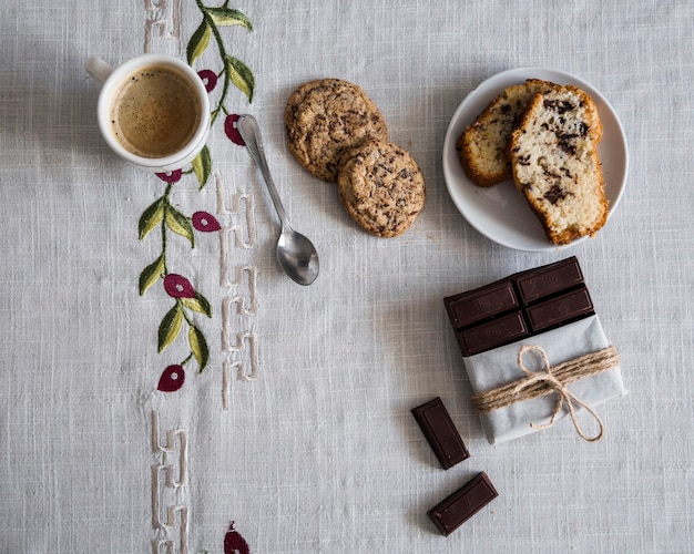 Vue élevée du café avec des biscuits, du pain et du chocolat Photo gratuit
