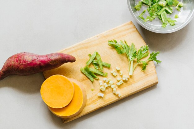 Vue élevée de patate douce; tranches de citrouille et de céleri sur une planche à découper Photo gratuit
