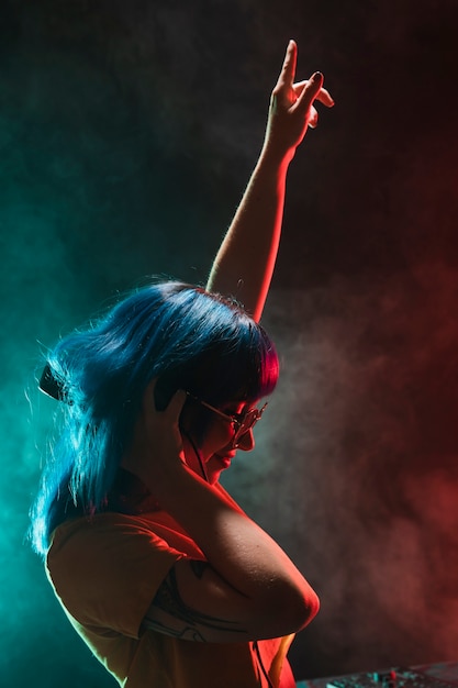 Vue de face femme dj avec la main levée Photo gratuit
