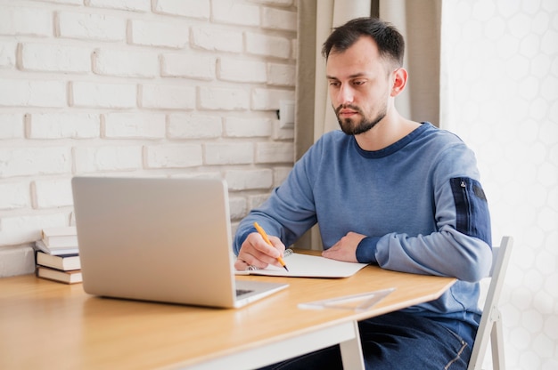 Vue De Face De L Homme Au Bureau D Apprentissage En Ligne A Partir D Un Ordinateur Portable Photo Gratuite