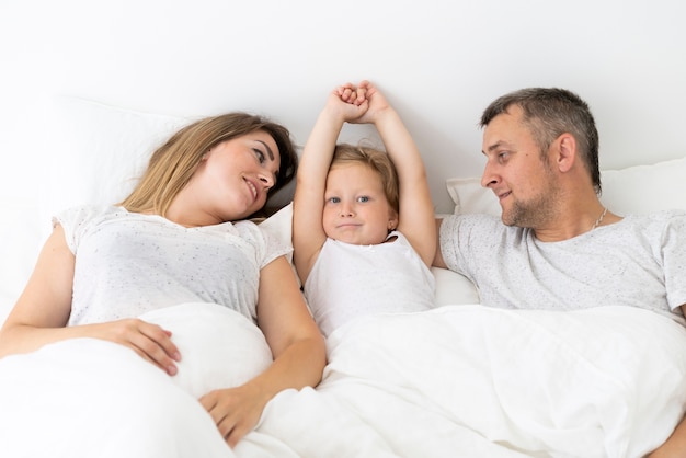 Vue de face, parent, reposer dans lit, à, fille Photo gratuit