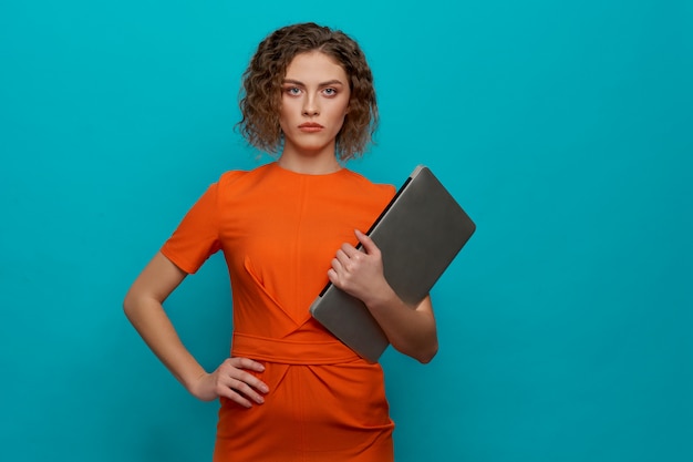 Vue frontale, de, femme sérieuse, tenant ordinateur, dans, mains Photo Premium