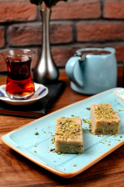 Vue Laterale Du Baklava De Bonbons Turcs A La Pistache Servi Avec De La Creme Glacee Sur Le Plateau Photo Gratuite