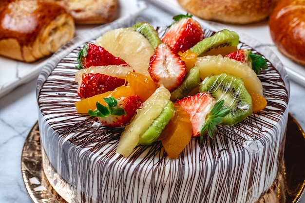 Vue Laterale Gateau Aux Fruits Avec Creme Vanille Chocolat Kiwi Orange Ananas Et Fraise Photo Gratuite