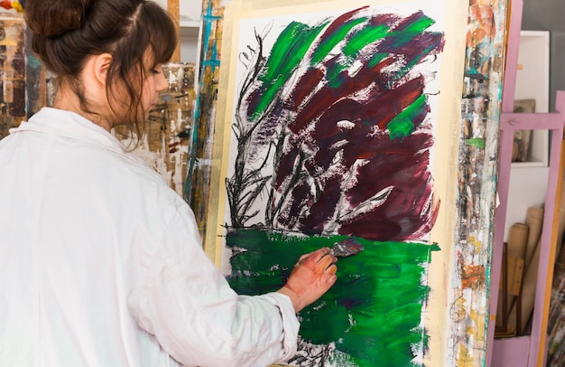Vue postérieure, de, femme, peinture, sur, désordre, toile, à, atelier Photo gratuit