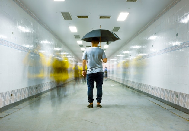 Vue postérieure, de, a, homme, tenue, parapluie, à, floue, gens, longue, exposition, technique Photo gratuit