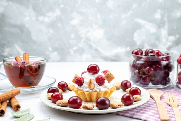 Vue Rapprochee Avant Petit Gateau Cremeux Aux Framboises Cerises Et Petits Biscuits The Cannelle Sur Bureau Leger Photo Gratuite