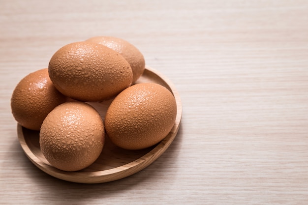 Vue rapprochée des oeufs de poule sur fond de table en bois Photo Premium