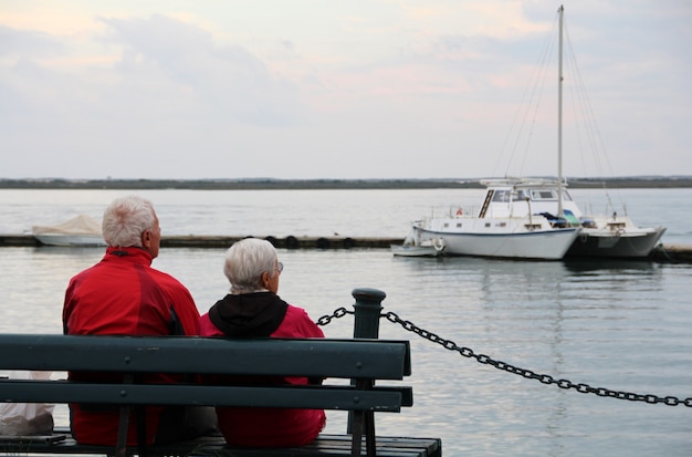 Vue rapprochée d'un vieux couple solitaire sur le banc en regardant l'océan. Photo Premium