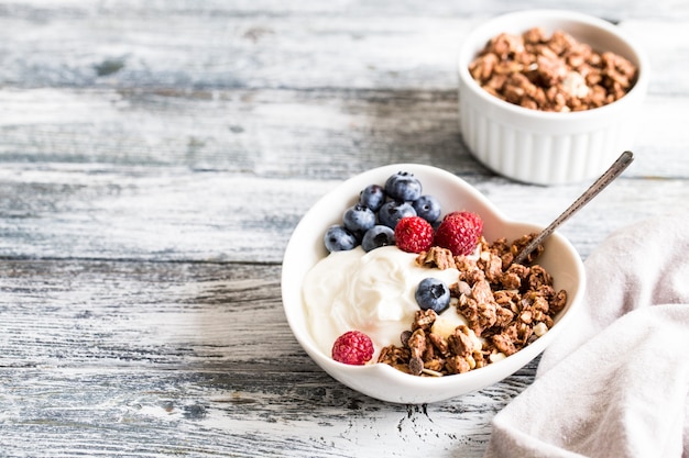 Yaourt Grec Myrtilles Framboises Et Granola Dans Un Bol Blanc Photo