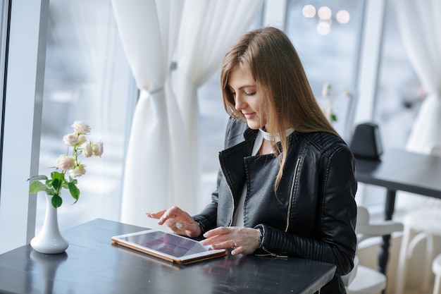 Femme assise dans un restaurant de toucher une tablette  Télécharger