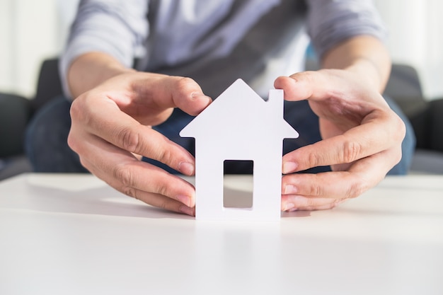 Les hommes d'affaires tiennent le modÃ¨le de maison en main Photo gratuit