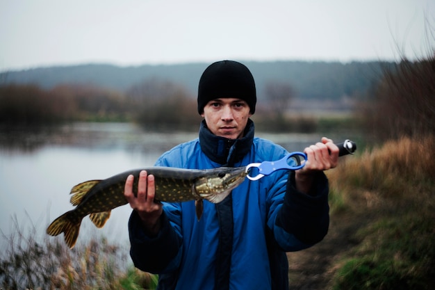 Portrait d'un homme tenant un poisson brochet Photo gratuit Portrait d'un homme tenant un poisson brochet Photo gratuit