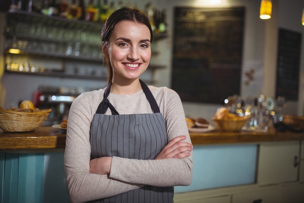 Portrait de sourire serveuse debout au comptoir Photo gratuit Portrait de sourire serveuse debout au comptoir Photo gratuit