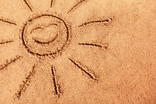 sourire soleil dessine sur une plage de sable