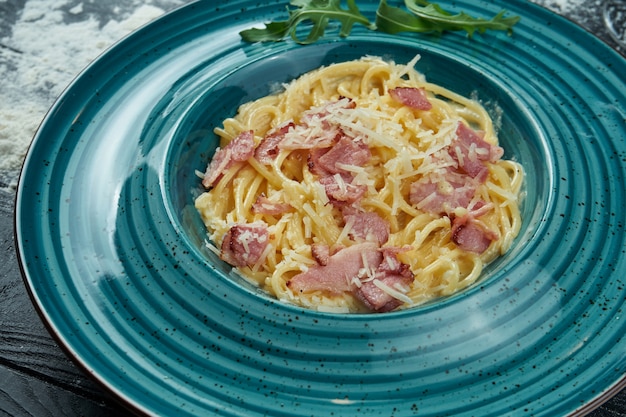 Appetitosa Pasta Alla Carbonara Fatta In Casa Con Pancetta Salsa Di Panna E Parmigiano In Un Piatto Blu Primo Piano Vista Dall Alto Spaghetti Italiani Foto Per La Ricetta Foto Premium