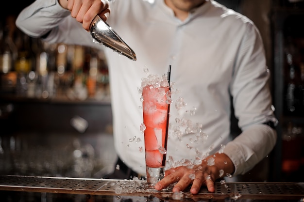 Barman Aggiungendo Cubetti Di Ghiaccio Nel Bicchiere Con Cocktail Estivo Alla Fragola Mojito Foto Premium