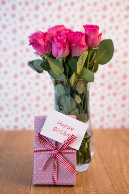 Mazzo Di Rose Rosa In Vaso Con Il Regalo Rosa Che Si Appoggia Contro Di Esso E Carta Di Buon Compleanno Foto Premium