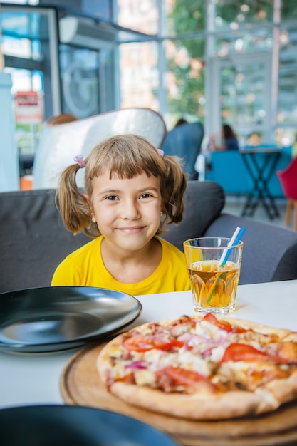 Il Bambino Mangia La Pizza Al Formaggio Foto Premium