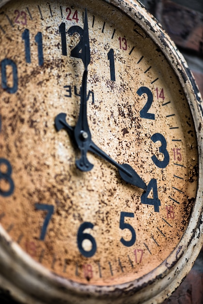 Close-up di vecchio orologio situato sul muro di mattoni | Foto Premium