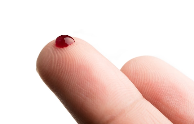 Goccia di sangue sul dito su sfondo bianco | Foto Premium