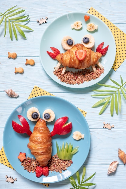 Cibo Divertente Per Bambini Graziosi Croissant Di Granchio E Aragosta Con Frutta Per La Colazione Dei Bambini Foto Premium