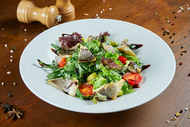 Insalata Gourmet Servita Con Branzino Arrosto Spinaci Lattuga Pomodorini Su Un Tavolo Di Legno Insalata Di Mare Deliziosa Cibo Salutare Dieta E Fitness Fitness Foto Premium