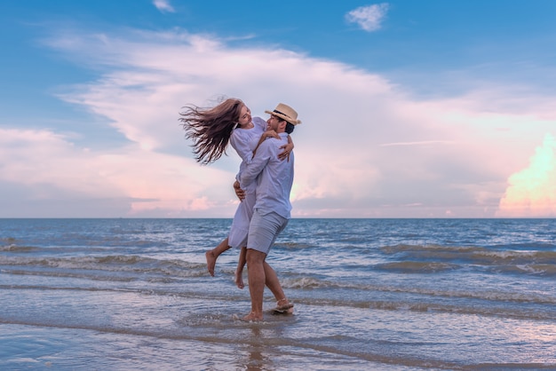 Giovani Coppie Felici Che Si Tengono E Che Ridono Con Il Godimento Insieme Sulla Spiaggia Di Estate Foto Premium