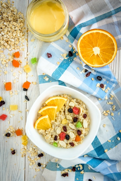 Porridge Di Farina D Avena Fatto In Casa Con Arancia E Frutta Candita Su Uno Spazio Di Legno Bianco Foto Premium