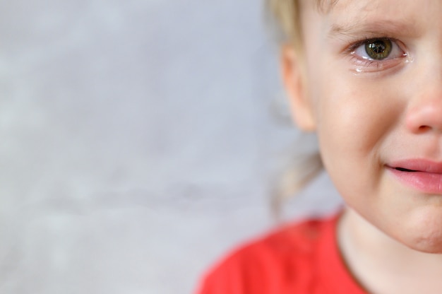 Bambino Che Piange Il Volto Di Un Simpatico Ragazzino Di Quattro Anni Sconvolto In Lacrime Dolore Dei Bambini Sfondo Grigio Muro Di Cemento Spazio Per Il Testo Foto Premium