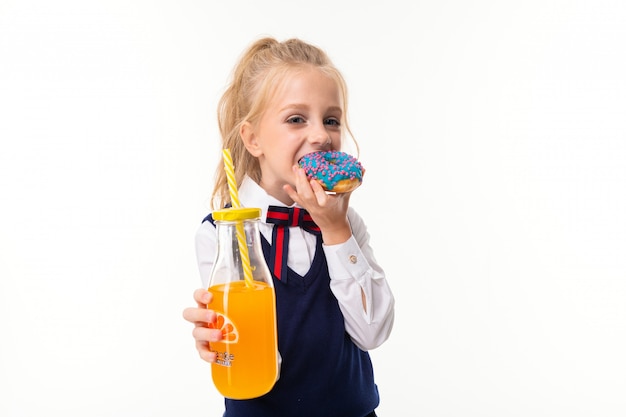 L Immagine Di Una Bambina Con I Capelli Biondi Mangia La Ciambella E Beve Il Succo D Arancia Foto Premium