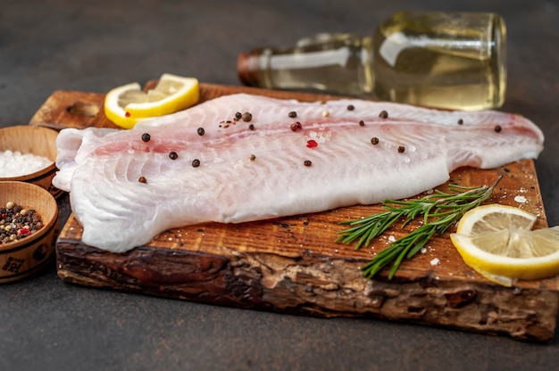 Filetto Di Pangasio Crudo Su Un Tagliere Con Limone Olio E Spezie Pesce Crudo Foto Premium