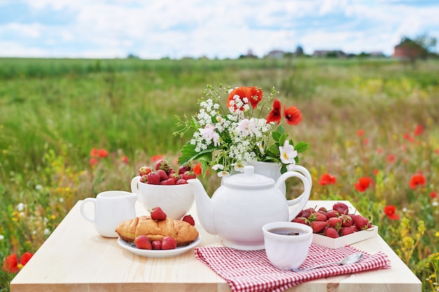 Romantica Colazione Francese O Rurale Di San Valentino Te Fragole Cornetti Sul Tavolo In Un Campo Di Papaveri Campagna E Accogliente Buongiorno Concetto Di Fine Settimana Foto Premium