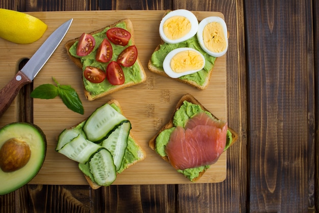 Panini con avocado e diversi ingredienti sullo sfondo di ...