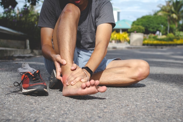 Sport uomo che tiene la caviglia nel dolore a causa della distorsione alla  caviglia. lesione dal concetto di allenamento | Foto Premium