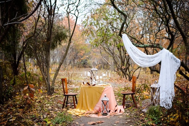 Il Tavolo Con Un Arredamento Autunnale Posato Per Due Nel Bosco Matrimonio Autunnale Decorazioni Di Nozze Foto Premium