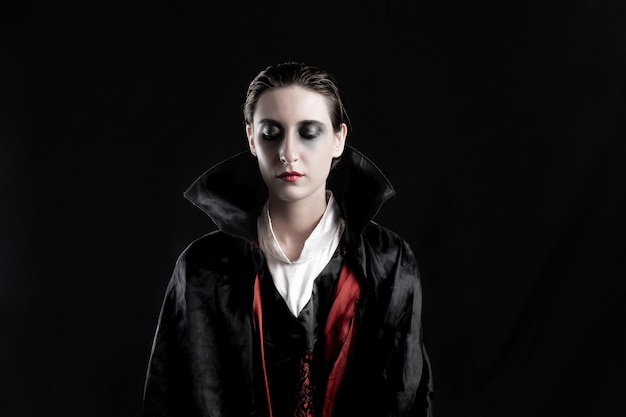 Donna Vestita Da Vampiro Per Halloween Studio Girato In Luci Drammatiche Di Una Giovane Donna In Costume Di Dracula Su Sfondo Nero Foto Premium