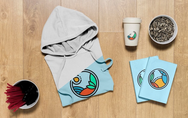 Download Bovenaanzicht gevouwen hoodie mock-up met notitieboekjes en zonnebloempitten | Gratis PSD Bestanden