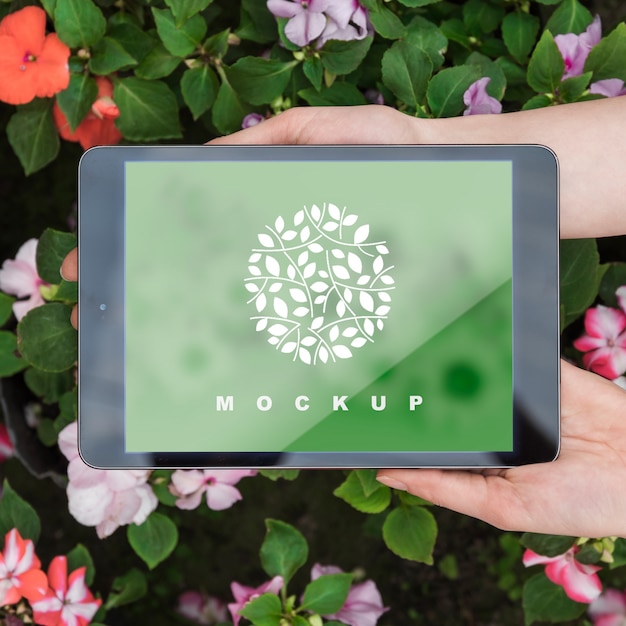 Handen met tablet mockup met tuinieren concept Gratis Psd