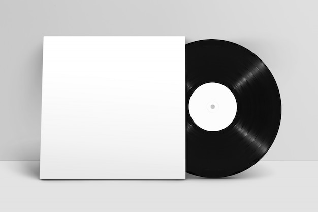 Modello della vista frontale che sta l'annotazione di vinile in bianco con la copertura contro la parete bianca Psd Premium
