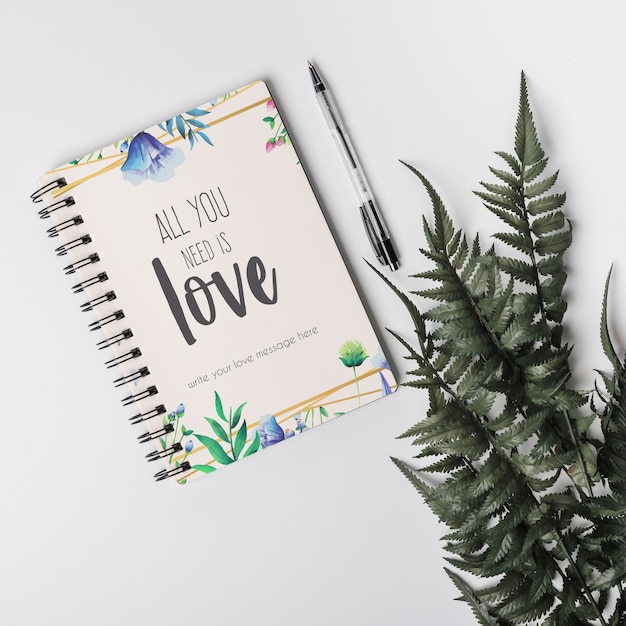 Notebook mockup naast bladeren Gratis Psd