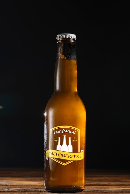 Bouteille de bière vue de face avec fond noir Psd gratuit