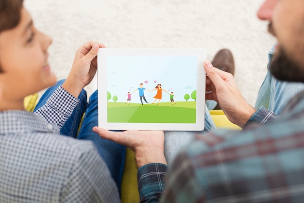 Maquette père et fils en regardant sur une tablette Psd gratuit
