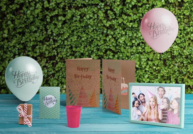 Vue de face des éléments d'anniversaire sur une table en bois Psd gratuit