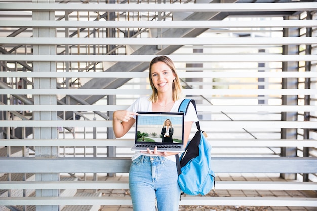 De volta ao conceito de escola com laptop apresentando menina Psd grátis
