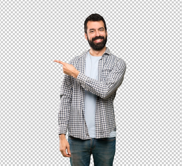 Homem bonito com barba apontando para o lado para apresentar um produto Psd Premium