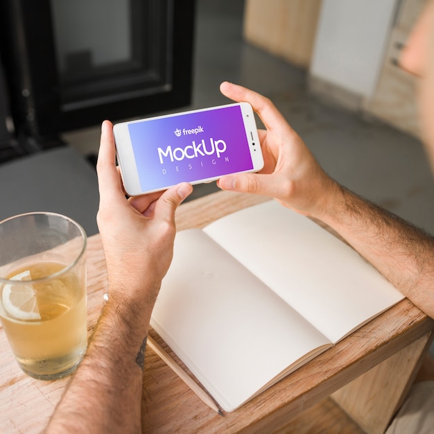 Jovem com uma maquete de smartphone Psd grátis