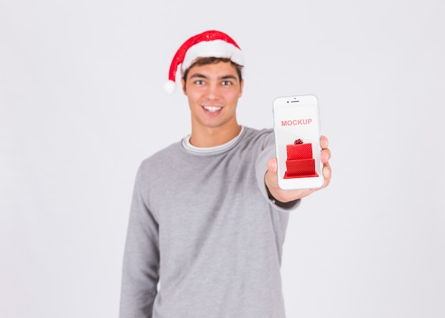 Maquete de venda de natal com a mão segurando o smartphone Psd grátis