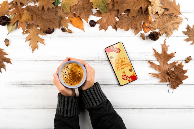 Pessoa de close-up com café e smartphone Psd grátis